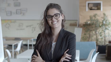 Businesswoman-standing-with-crossed-arms-and-smiling-at-camera