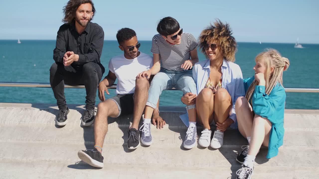 jóvenes amigos con estilo en el terraplén de la ciudad