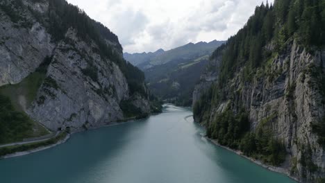 amazing pass way between great rocky mountains covered with forest and great signs in the clouds water is pure vivid crystal clear footpath on the side for people to explore adventure bird view nice