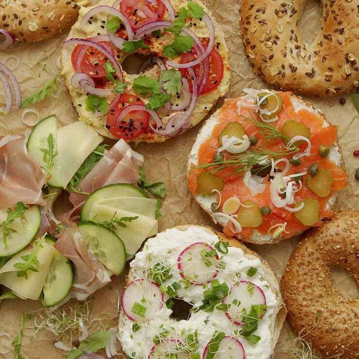 Bagel gustosi, colorati e vari con ingredienti sani serviti su carta da forno marrone