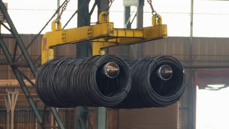 overhead crane carrying steel cable inside factory