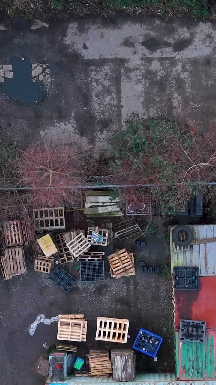 Rev nærmer seg industriområdet mens en vertikal drone i fugleperspektiv rygger over fraktcontainere, paller og parkerte lastebiler, og viser byens dyreliv som tar seg inn i et røft logistikkområde
