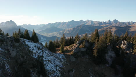 Foque-Hacia-Abajo-De-La-Cima-De-La-Montaña-Con-árboles-Con-Grandes-Montañas-En-El-Fondo