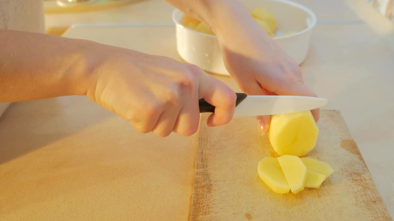 여성 손은 부에서 감자를 잘라
