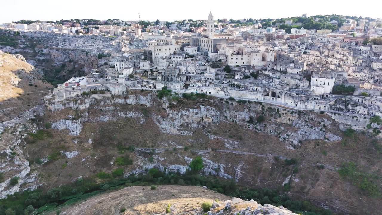 Iconic Matera city and deep valley side, aerial view