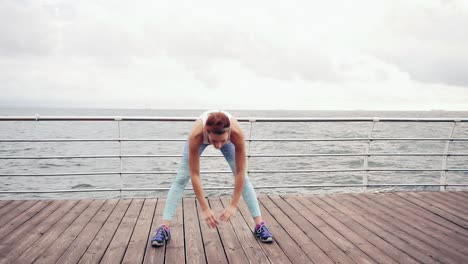 Mujer-Corredora-Estirándose-Y-Haciendo-Arcos-Laterales.-Atleta-Femenina-Relajándose-En-La-Playa-Haciendo-Un-Calentamiento-Antes-De-Su-Entrenamiento-Cardiovascular