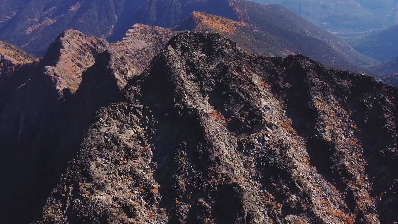 orbitando el pico montañoso escarpado y rocoso en las montañas purcell, toma aérea de otoño