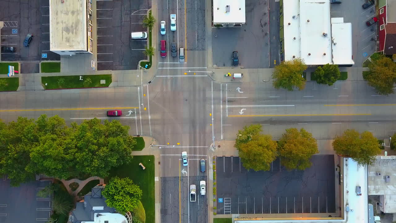 Drone follows a red car turning left at a four way stop.