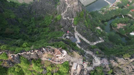 Lying-Dragon-Statue-on-Mountain-Top-at-Mua-Cave-Viewpoint-in-Ninh-Binh-Vietnam-at-Sunset---Aerial-Filting-Down-Flyover