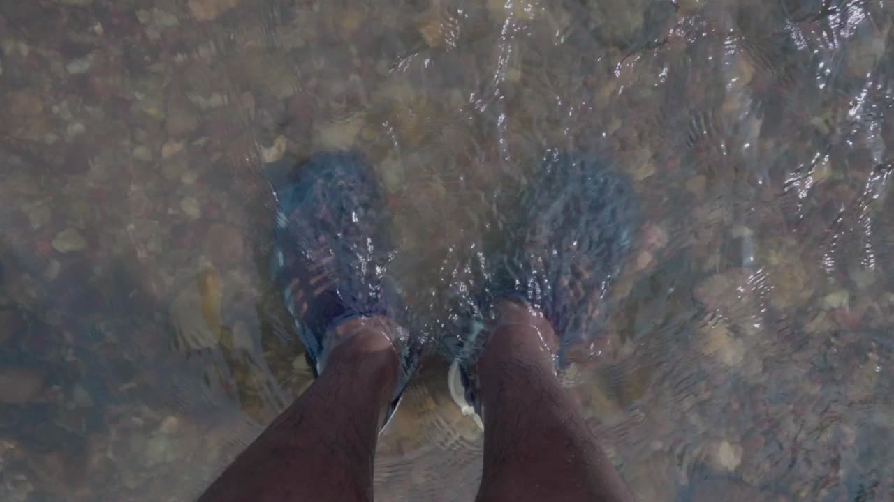 piede nel fiume di acqua limpida naturale