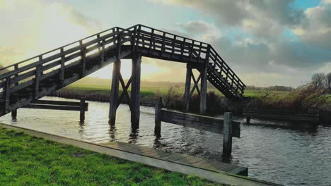 Puente-Peatonal-De-Madera-Sobre-El-Agua-Con-Una-Puesta-De-Sol