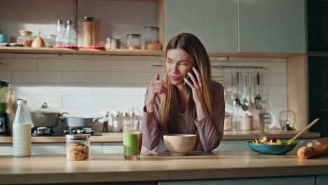 happy woman calling kitchen countertop. happy girl talking smartphone at morning