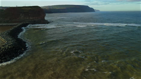 Disparo-De-Un-Dron-Sobrevolando-Staithes-Por-La-Costa-De-Los-Acantilados-Hacia-Saltburn