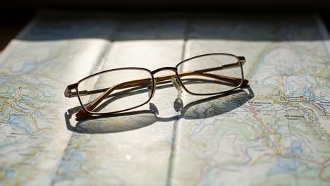 a pair of glasses resting on a detailed map, symbolizing exploration, discovery, and adventure in an artistic light