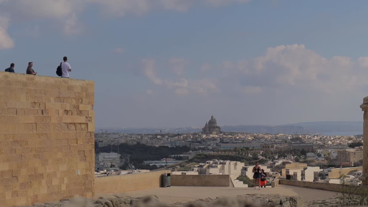 Panoramic view with visitors and travelers at the walls surrounding the Citadel in Gozo, Malta, capturing the essence of historical exploration and cultural immersion
