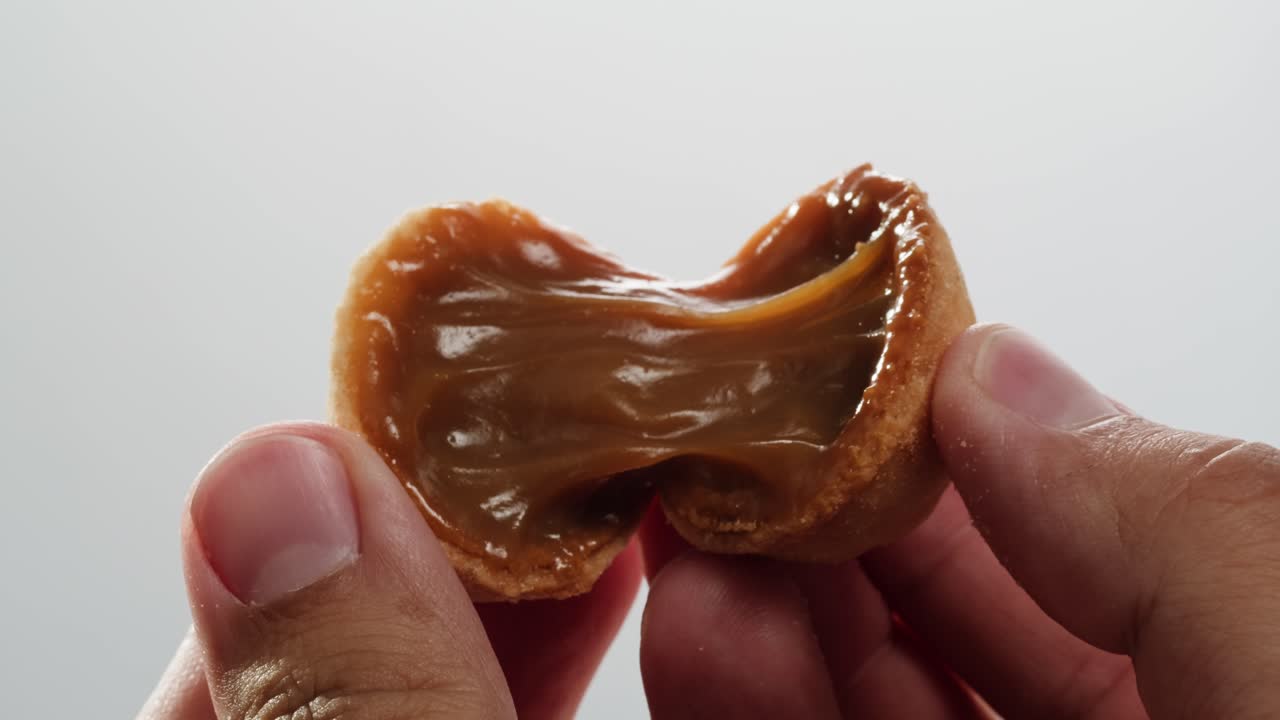 집에서 만든 견과류 모양의 쿠키와 여진 응축 우유가 회색 테이블에 평평하게 놓여 있습니다. 고품질의 4k 영상