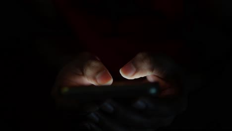 hands using a smartphone in the dark
