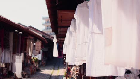 오래된 시장에서 바람에 매달려 있는 흰색 리넨 드레스