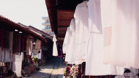 white linen dress hanging in the wind in an old market place