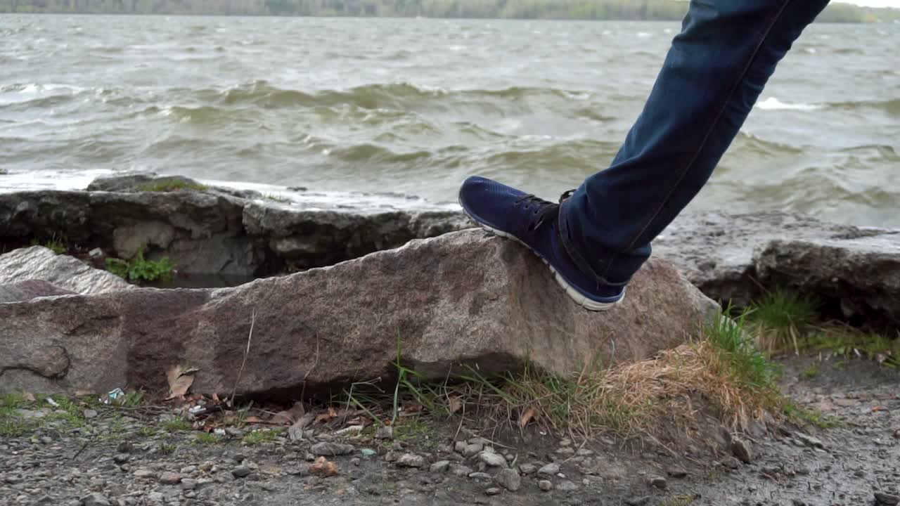 Person standing on a rock by the lake