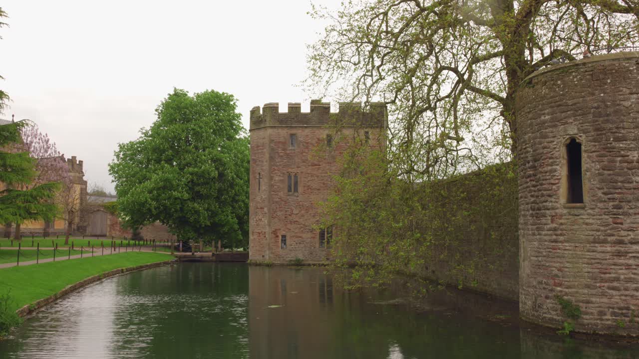Middelalderligt bispepalads i Wells, England, med voldgrav og frodigt grønt