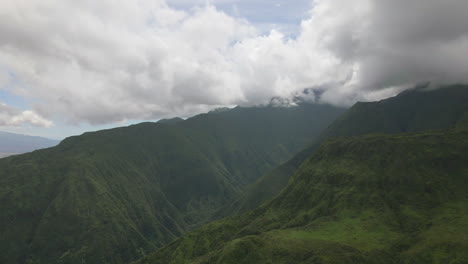 Storm-clouds-on-top-of-Maui-rainforest-mountain,-sunlight-and-rain