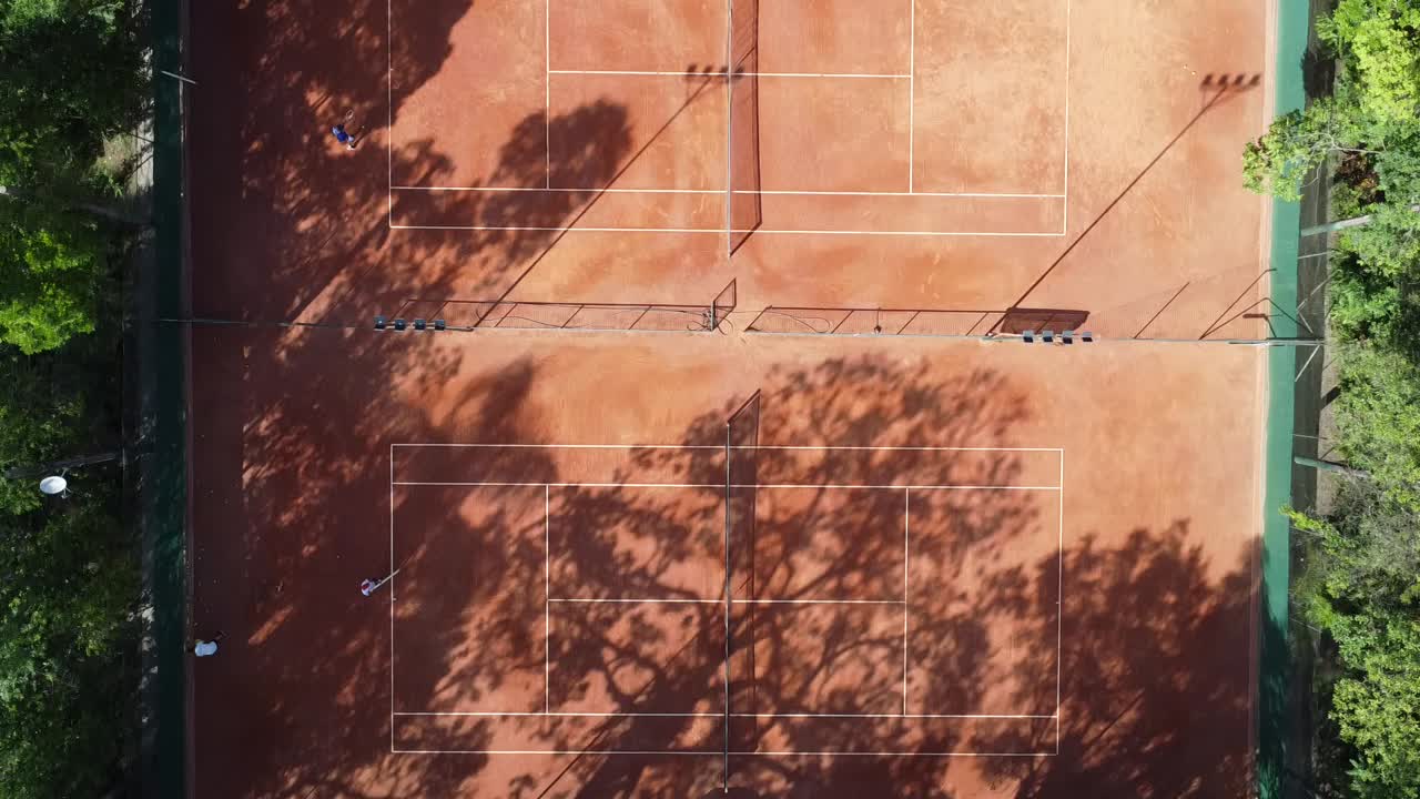 드론 촬영을 통해 나무와 많은 자연 속에서 아름다운 테니스 코트 아래로 이동, 이른 아침