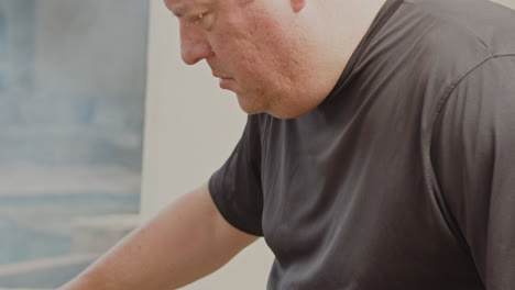 Man-uses-tongs-to-turn-over-BBQ-chicken-thighs-in-smoking-grill