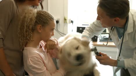 mother and daughter with dog in the vets