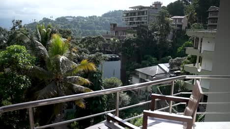 a balcony with wooden seating offers a picturesque view of lush greenery and tropical surroundings in kandy, sri lanka, radiating peace and relaxation.