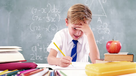 Schoolboy-doing-his-homework-in-classroom