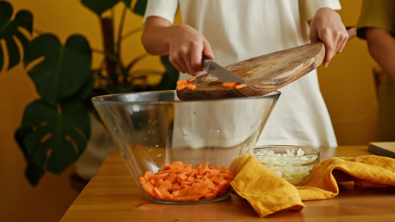 adolescente de la cosecha poniendo zanahoria en el cuenco