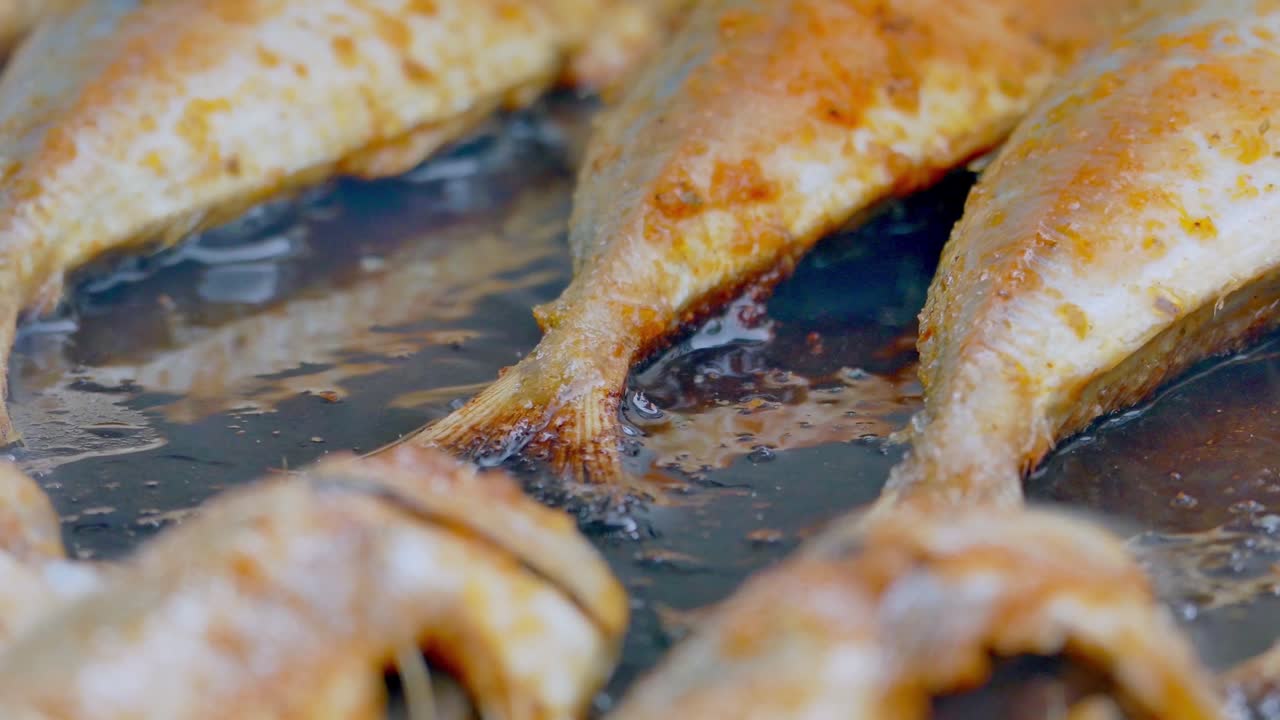 pescado a la parrilla delicioso y jugoso en un plato de hierro. hornear y asar pescado marinado en una parrilla de barbacoa. 4k barbacoa y primer plano