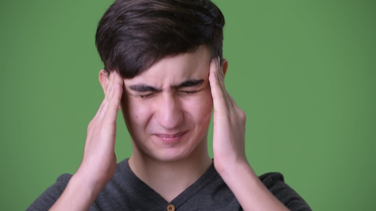 joven y guapo adolescente iraní contra un fondo verde