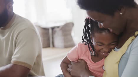 Happy-african-american-couple-with-daughter-enjoying-meal-in-dining-room,-slow-motion