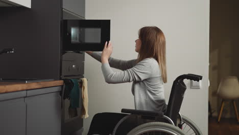 woman with disability retrieves warm lunch from microwave