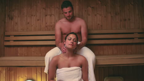 Man-giving-his-girlfriend-a-neck-massage-in-the-sauna