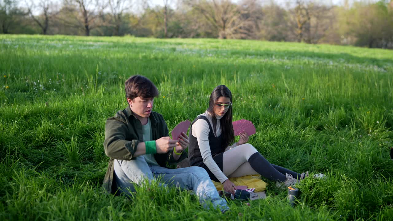 Couple Playing Cards in a Park