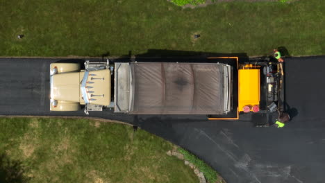 Top-down-aerial-view-of-workers-paving-driveway