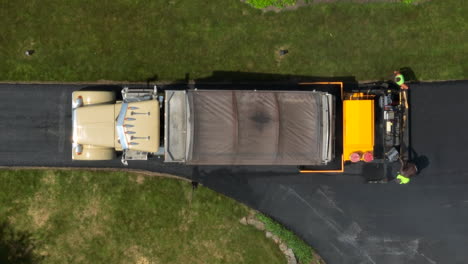 top down aerial view of workers paving driveway