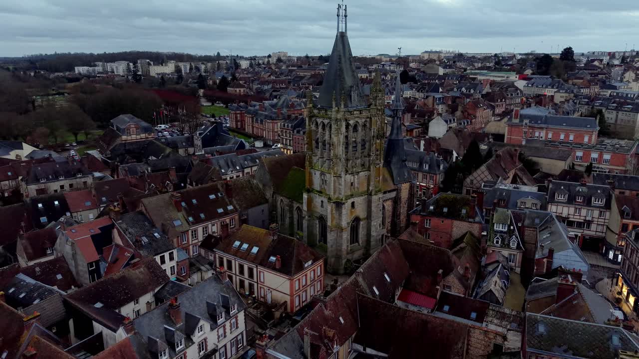 Storica chiesa di Saint Martin e tetti del centro storico al tramonto a L'Aigle, Normandia, Francia. Ripresa aerea all'indietro.
