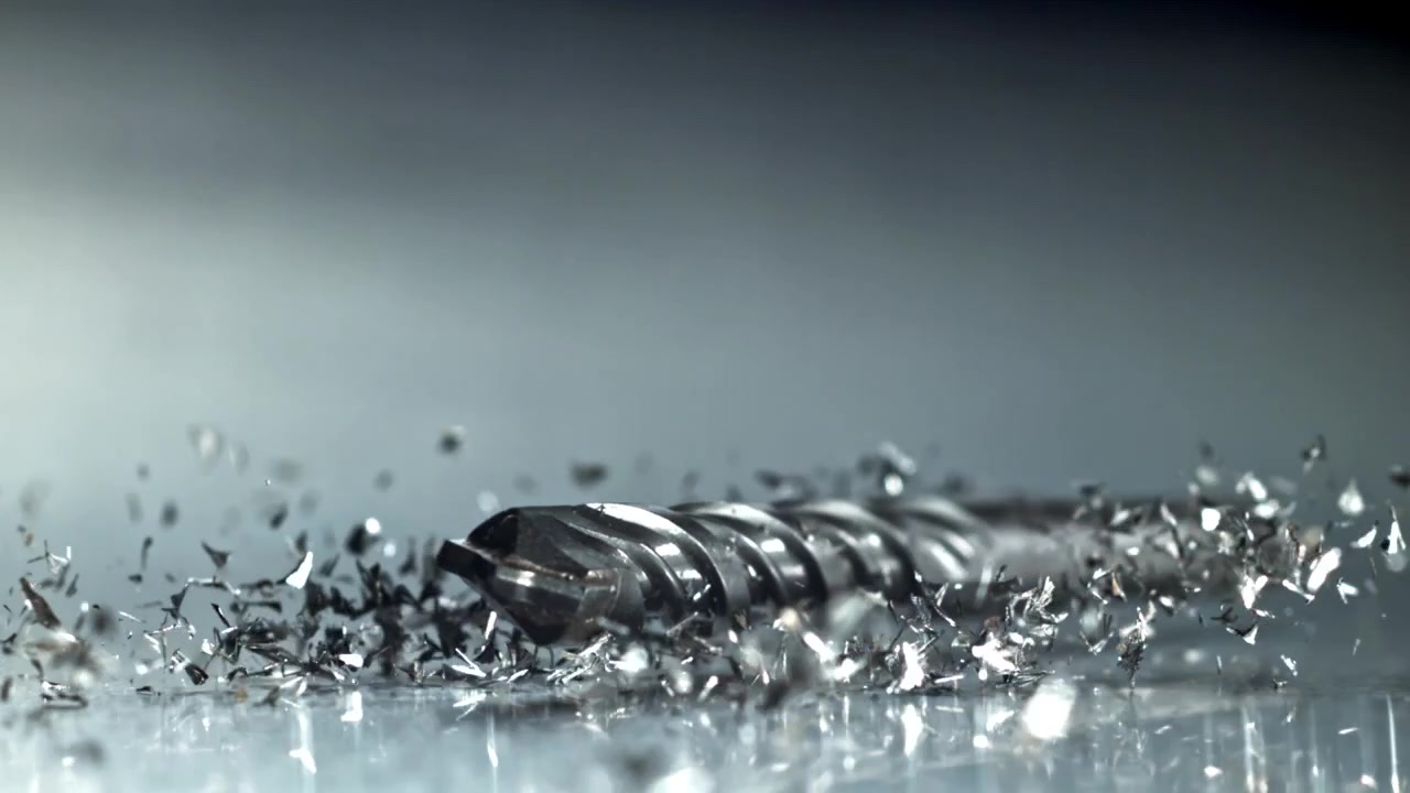 Slow Motion Close-Up of a Drill Bit Dropping onto Metal Shavings