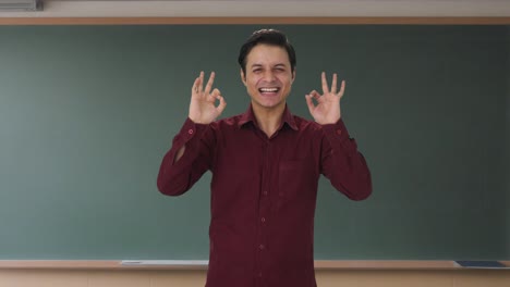 un maestro indio feliz mostrando una señal de bien