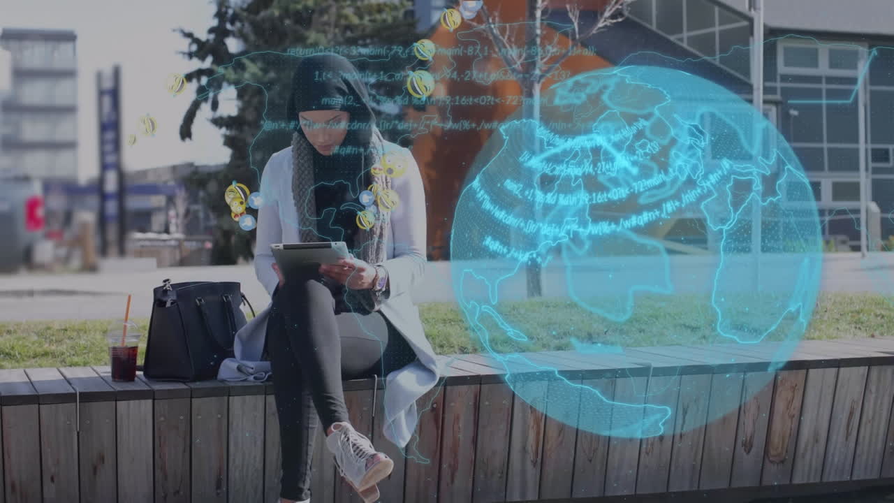 animación de emoticones, datos y globo sobre mujer biracial usando tableta al aire libre