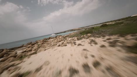 FPV-drone-forward-moving-shot-over-rocky-beaches-with-spectacular-cliffs-in-Cala-Varques,-Mallorca,-Spain-during-evening-time