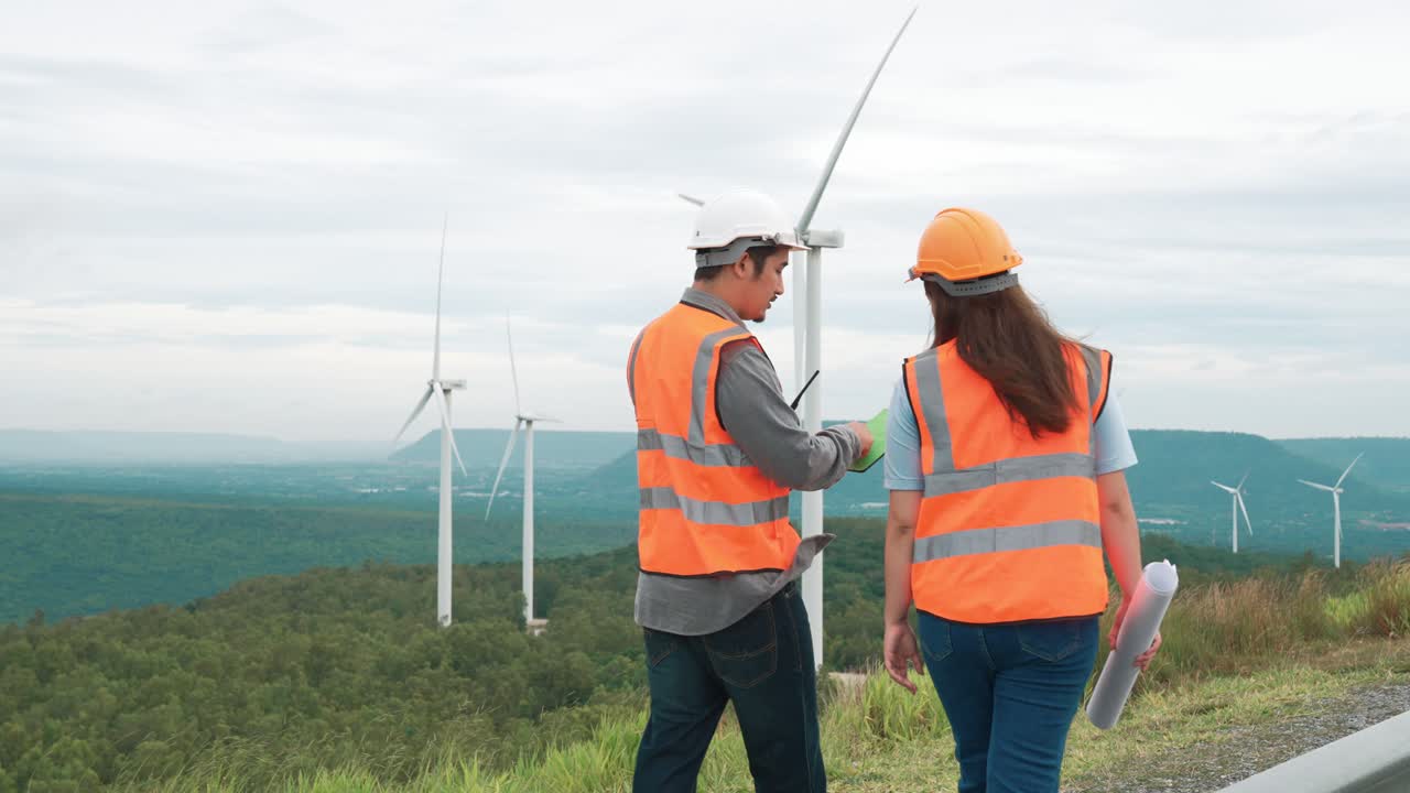 Progressive concept of engineers working in the wind farm atop of the mountain.