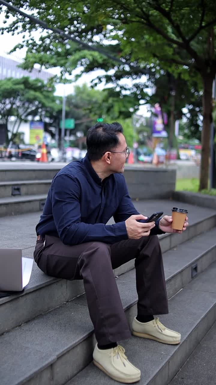 Relaxed businessman on steps checking phone with coffee blending work and leisure in urban settings