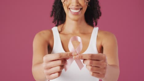 Video-De-Una-Mujer-Birracial-Sonriente-Sosteniendo-Una-Cinta-Rosa-Contra-El-Cáncer-De-Mama