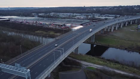 mersey gateway toll bridge highway traffic driving across river estuary aerial view high tilt down pan left