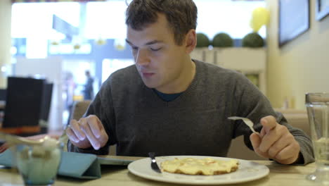 Mann-Benutzt-Pad-Und-Isst-Im-Café-Zu-Abend